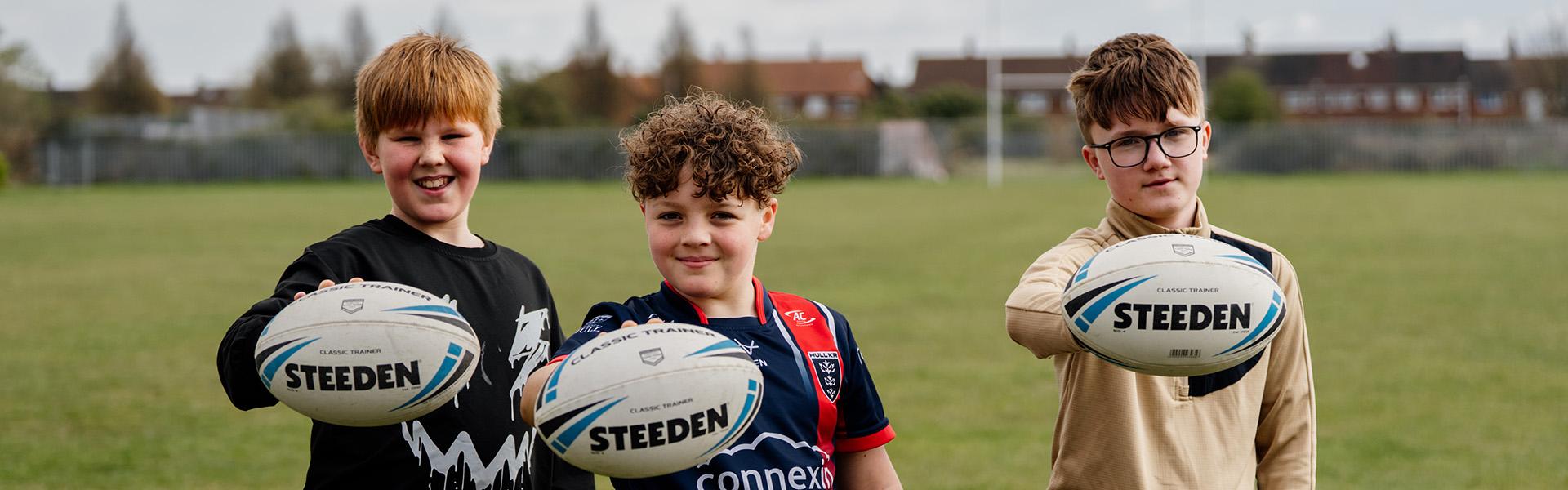 Three children with footballs